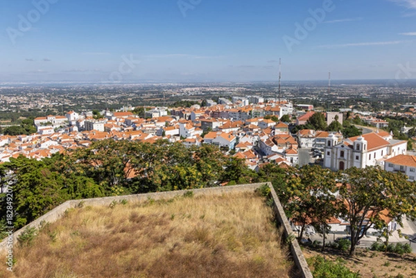 Fototapeta High angle aerial view of the town of Palmela, Portugal, seen from the castle. White buildings with red terracotta roofs spread out to the horizon.