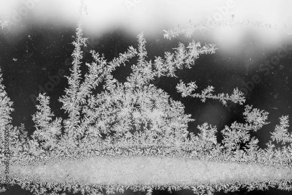 Fototapeta Wzorzysty szron na szybie na tle niebieskiego nieba