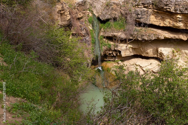 Fototapeta A small waterfall with a lake in the mountains.