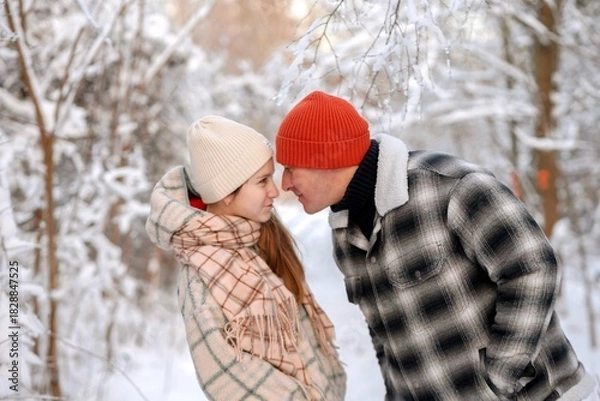 Fototapeta Father and daughter playing and enjoying the snow in a winter forest. Concept of family joy, warm emotions, childlike happiness, and fun winter activities outdoors.
