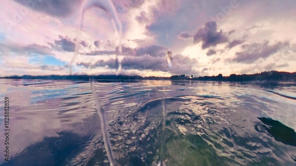 Fototapeta Drops of water on a water waves in a quiet water edge landscape in the sunset of a cloudscape in Chaweng Beach, Koh Samui, Thailand
