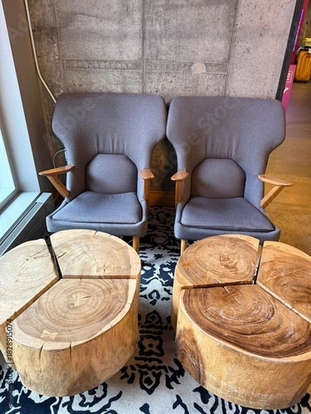 Obraz Modern Lounge Area: Two comfortable armchairs and wooden side tables against a concrete wall.