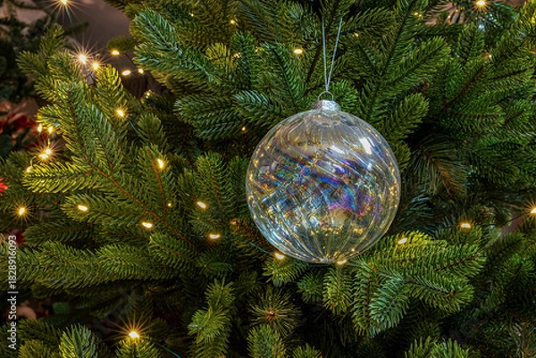 Fototapeta Silver Christmas ornament with soft reflections in gentle light
A silver Christmas ornament with soft reflections, surrounded by warm golden lights. Gentle focus enhances the festive mood.
