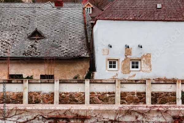Obraz Old Rustic Houses With Weathered Facades and Stone Wall
