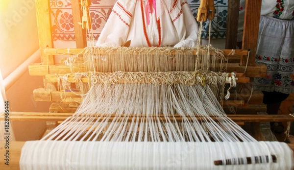 Obraz Weaver creating traditional textiles at a loom in a cultural workshop