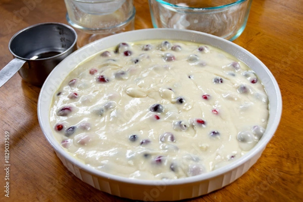 Fototapeta Thick homemade cranberry cake batter being mixed and prepared in a bowl for baking. Showing rich texture and suspended fresh fruit.
