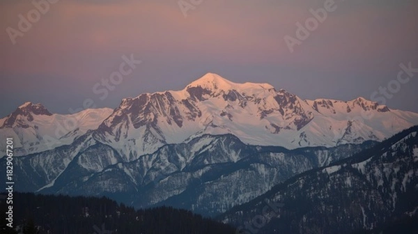 Obraz A breathtaking view of towering, snow-covered mountain peaks under a soft pastel sky.