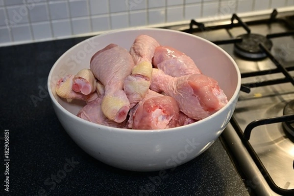 Obraz Raw chicken drumsticks in bowl on dark kitchen counter