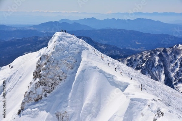 Fototapeta 雪の谷川岳に登る登山者たち
