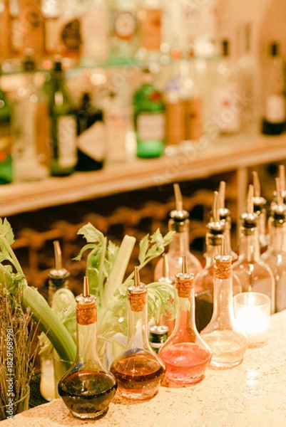 Fototapeta Variety of colorful liquor bottles lined up on a bar counter during an evening gathering