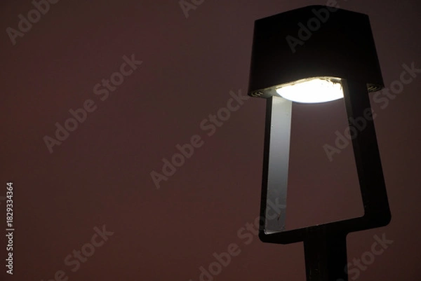 Obraz An LED bollard light, outdoor lighting fixture. Light with dusk background.