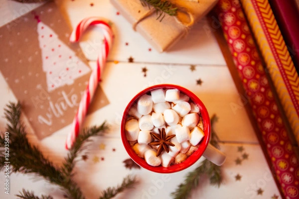 Fototapeta Cup of hot Chocolate drink. Cocoa with Marshmallows and cinnamon on wooden background with Christmas decorations.
