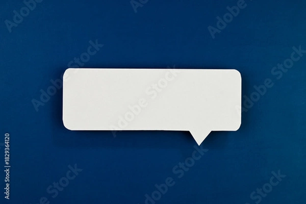 Obraz White speech bubble on blue background.