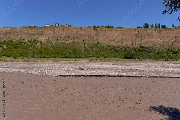 Fototapeta A muddy river in a canyon in the mountains.