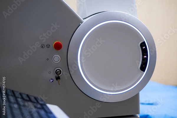 Fototapeta A close-up view of the operational control panel on the main unit of the ZEISS VISUMAX 800 Femtosecond Laser System, featuring the emergency stop, key lock, and a prominent illuminated ho