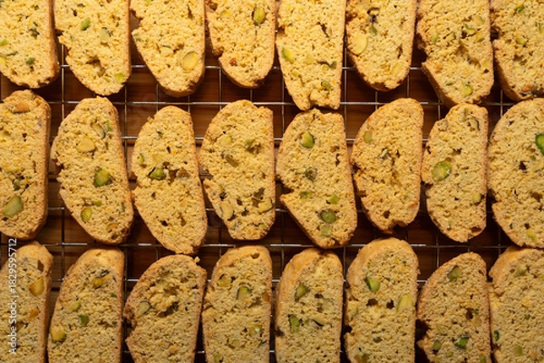 Fototapeta Freshly baked biscotti breakfast cookies with pistachio nuts, cooling on a wire rack