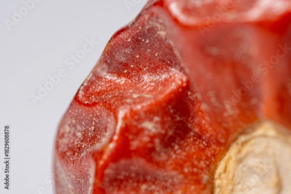 Fototapeta An extreme macro photograph capturing the intense red color, waxy texture, and subtle wrinkles on the surface of a chili pepper fruit, highlighting the stem base and granular res
