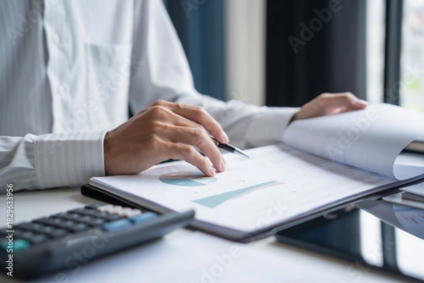 Fototapeta Professional Reviewing Business Data and Using Calculator.