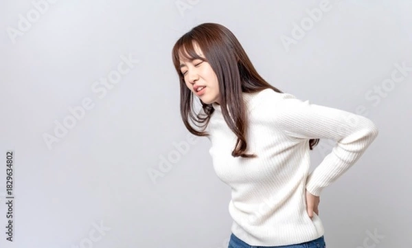 Obraz Young woman holding her waist with painful expression, backache and fatigue concept