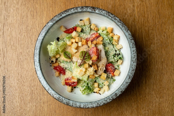 Fototapeta Bright greens and vibrant reds fill a stylish bowl. Croutons and delicate herbs add texture and flavor, creating a fresh and inviting dish perfect for a light meal