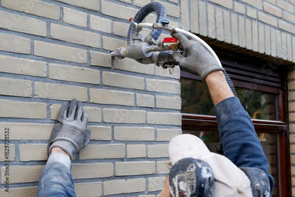 Fototapeta House insulation by injecting microbead pearls in the cavity walls