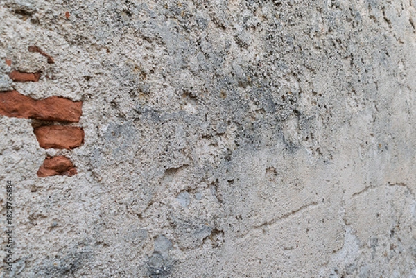 Fototapeta Textured surface of an old weathered brick wall with crumbling plaster