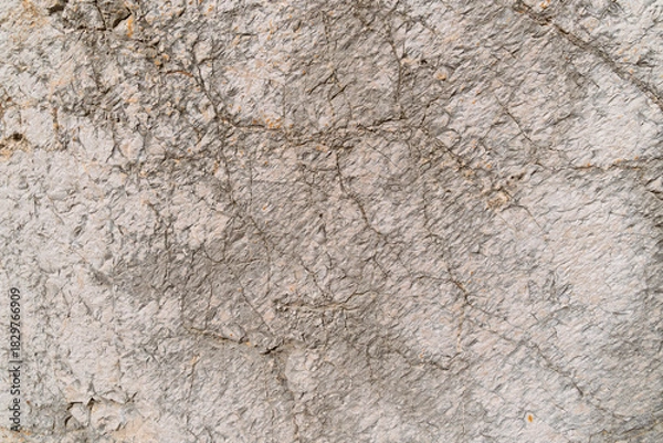 Fototapeta Close-up of rough gray concrete wall texture with cracks