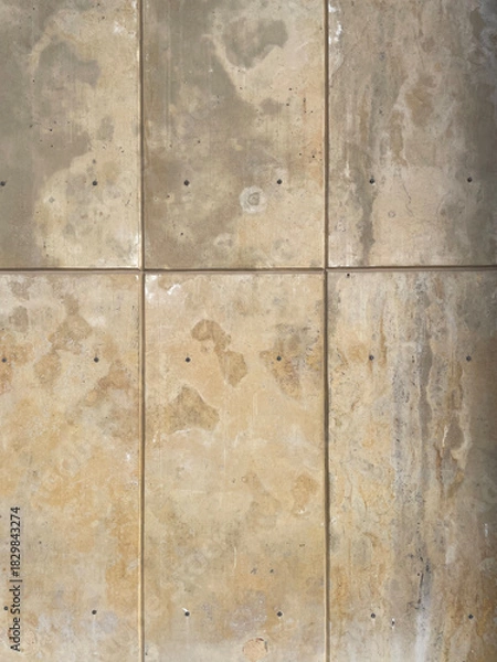Obraz Weathered beige concrete wall with vertical and horizontal tile divisions, subtle stains, scratches, and natural texture. Neutral industrial background suitable for design, architecture, and material 