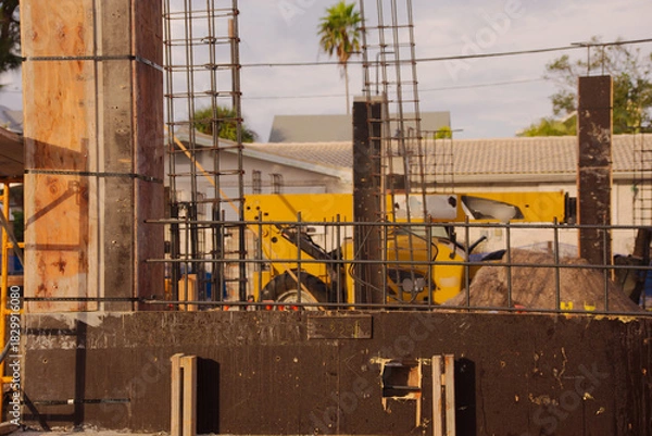 Obraz Active Construction Site With Signage, Rebar, and Wooden Forms in Early Stage Building. In St. Pete Beach, FL. Daylight highlights ongoing development, urban growth, and the sense of industry and prog