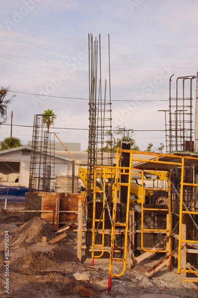 Obraz Active Construction Site With Signage, Rebar, and Wooden Forms in Early Stage Building. In St. Pete Beach, FL. Daylight highlights ongoing development, urban growth, and the sense of industry and prog