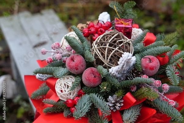 Fototapeta Christmas Floral Arrangement with Fir Branches, Red Ribbons and Holiday Decorations