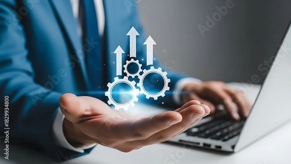 Obraz Businessman holding glowing gear icon with upward arrow graph