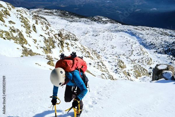 Obraz A unrecognizable mountaineer climbing a snowy mountain
