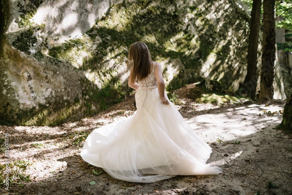 Fototapeta Beautiful stylish bride walking in the forest