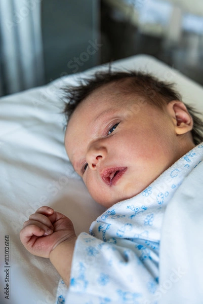 Fototapeta Newborn baby boy looking while resting in crib