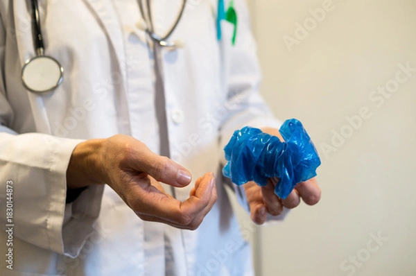 Obraz Doctor demonstrating how to safely remove gloves to avoid infection