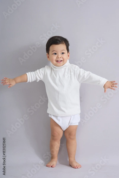 Obraz The child stands reaching sideways.