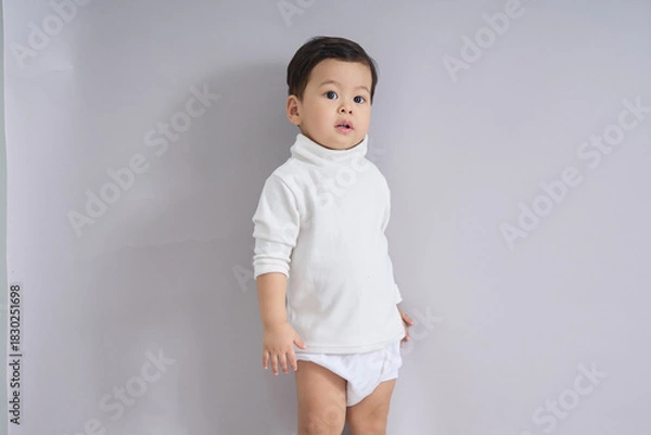 Obraz The child stands looking slightly downward.