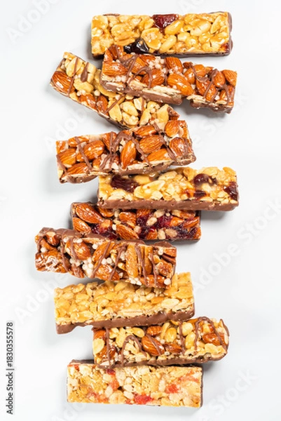 Fototapeta Delicious nut and fruit bars arranged in a colorful stack on a clean background