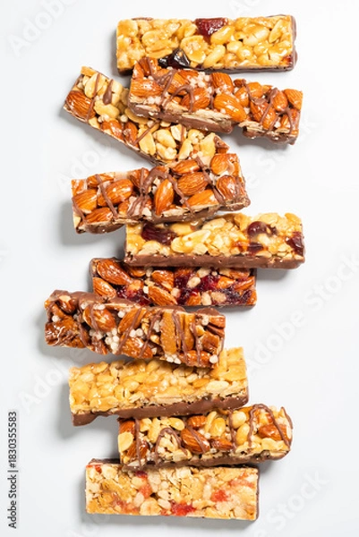 Fototapeta Delicious nut and fruit bars arranged in a colorful stack on a clean background