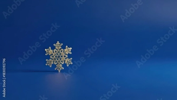 Obraz A single golden snowflake on a blue background.