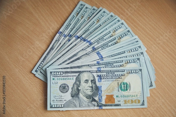 Fototapeta A stack of hundred dollar bills on the table