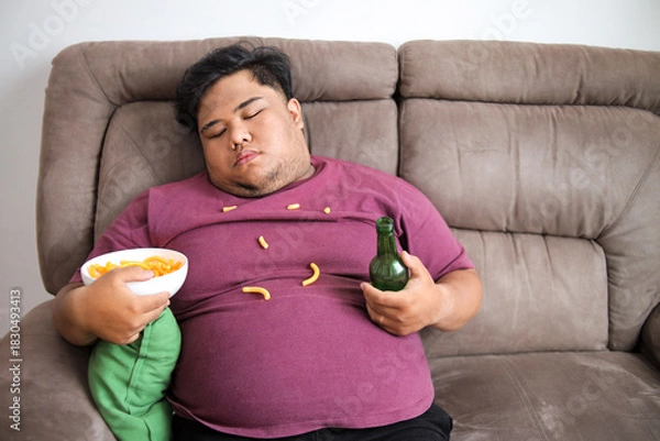 Obraz Big Man Takes Nap on Sofa While Drinking Beer and Snacking