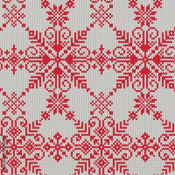 Fototapeta Knitted seamless pattern of white snowflakes on a red background