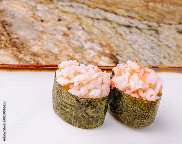 Fototapeta Delicious sushi rolls made with shrimp and seaweed on a marble surface