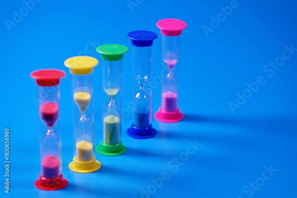 Obraz Hourglasses on blue background with copy space