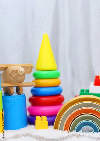 Obraz A vibrant display of childrens toys on a bright yellow backdrop, perfect for playful themes and joyful imagination. Vertical photo format