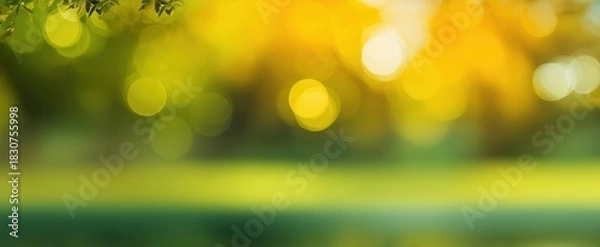 Fototapeta The Sunlit Bokeh Background With Green And Golden Autumn Leaves