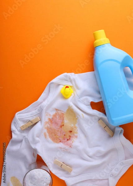 Obraz Vertical photo format.A Stained Baby Shirt, Resting with Detergent on a Bright Background Surface
