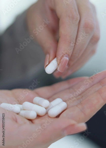 Obraz Vertical photo format. Taking Medication An InDepth Close Up View of Various Pills and Water for Hydration